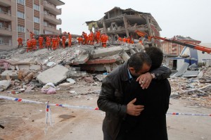 Двое мужчин на фоне разрушенного дома в Эркисе, восточная Турция